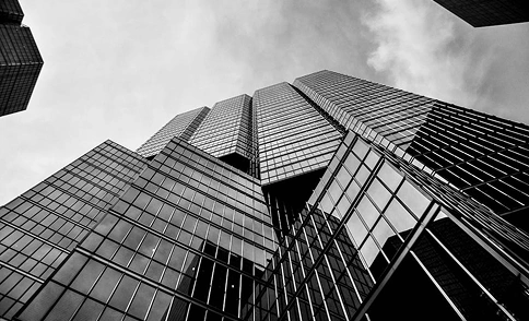 Laag perspectief van glazen torens die de lucht weerspiegelen, hedendaagse hoogbouwarchitectuur in zwart-wit.