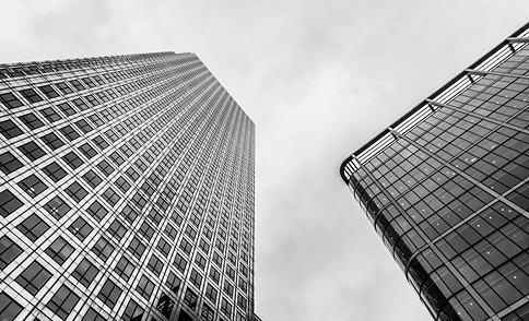 Zwart-witfoto van een wolkenkrabber met een rastergevelpatroon, moderne stedelijke architectuur en kantoorgebouwontwerp.