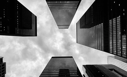 Symmetrisch perspectief van onderaf op wolkenkrabbers tegen een bewolkte hemel, een dramatische compositie van stedelijke architectuur.